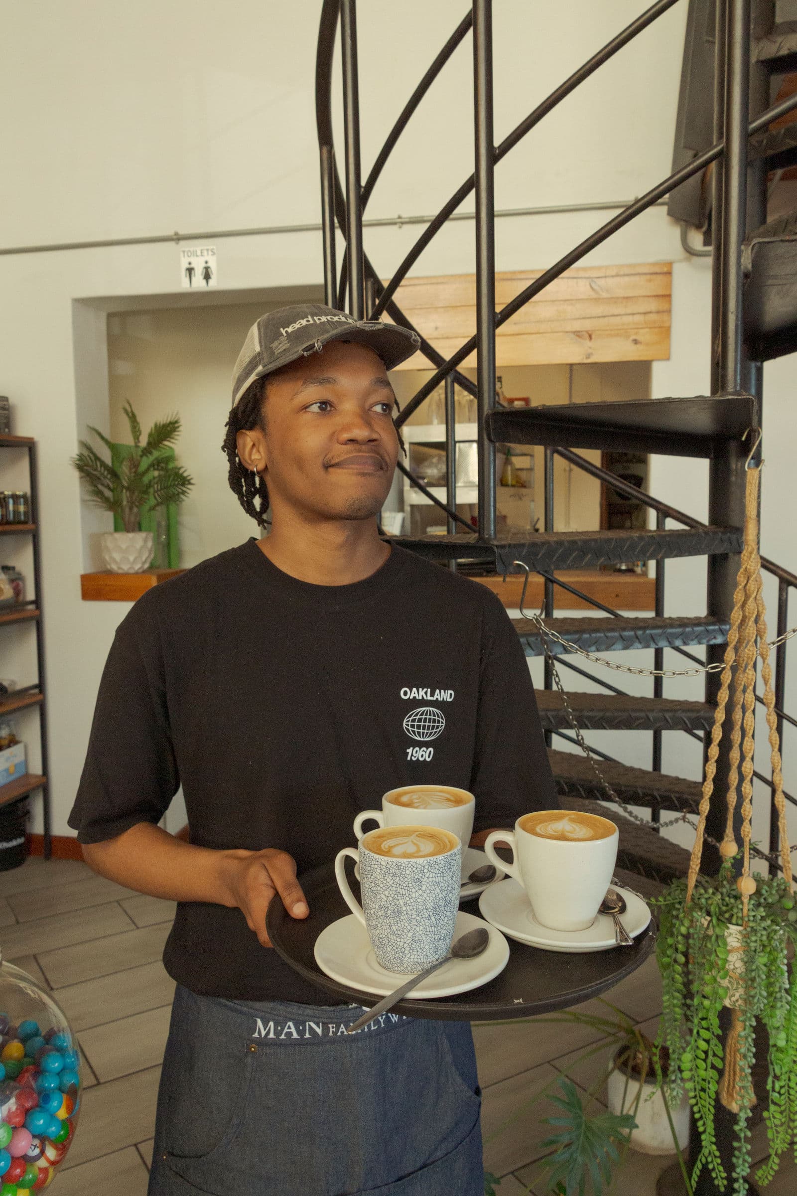 A barista carrying coffees through Empire Cafe